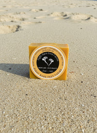 Kojic Acid + Manuka Honey + Turmeric Dark Spot Soap on sandy beach background, brightening skincare product.